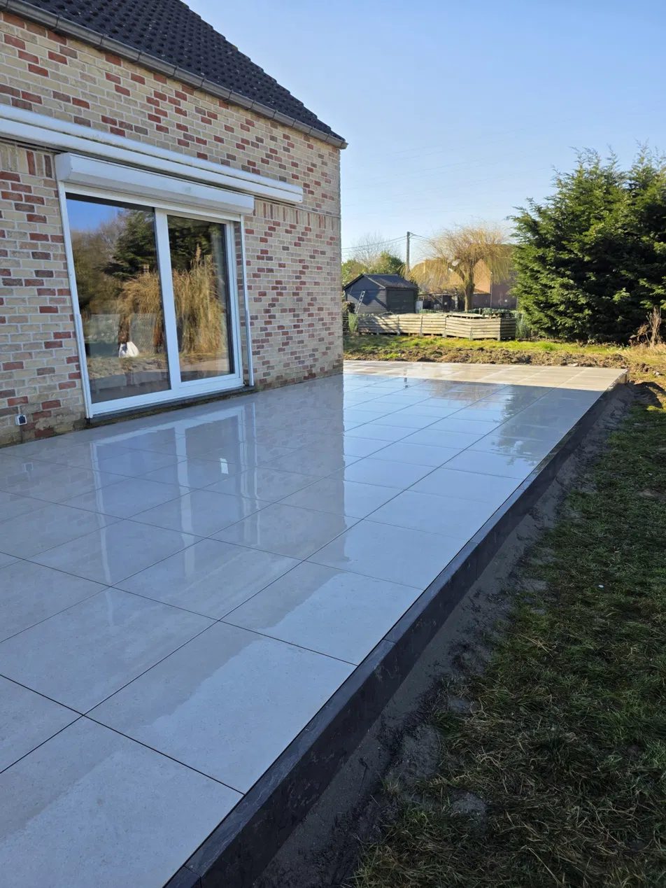 Terrasse en grès cérame avec baie vitrée coulissante réalisée par NDA Construct